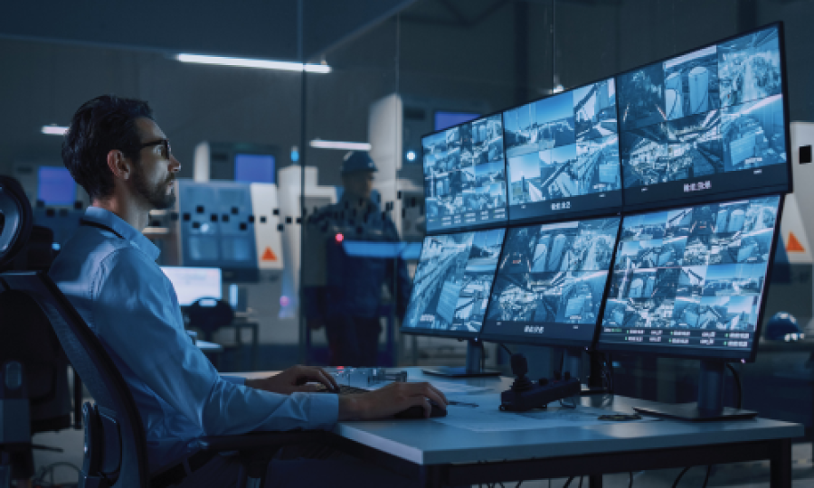 bearded man looking at blue security screens